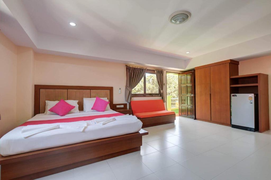 波普托Rak Samui Residence的卧室配有一张带粉红色枕头的大床