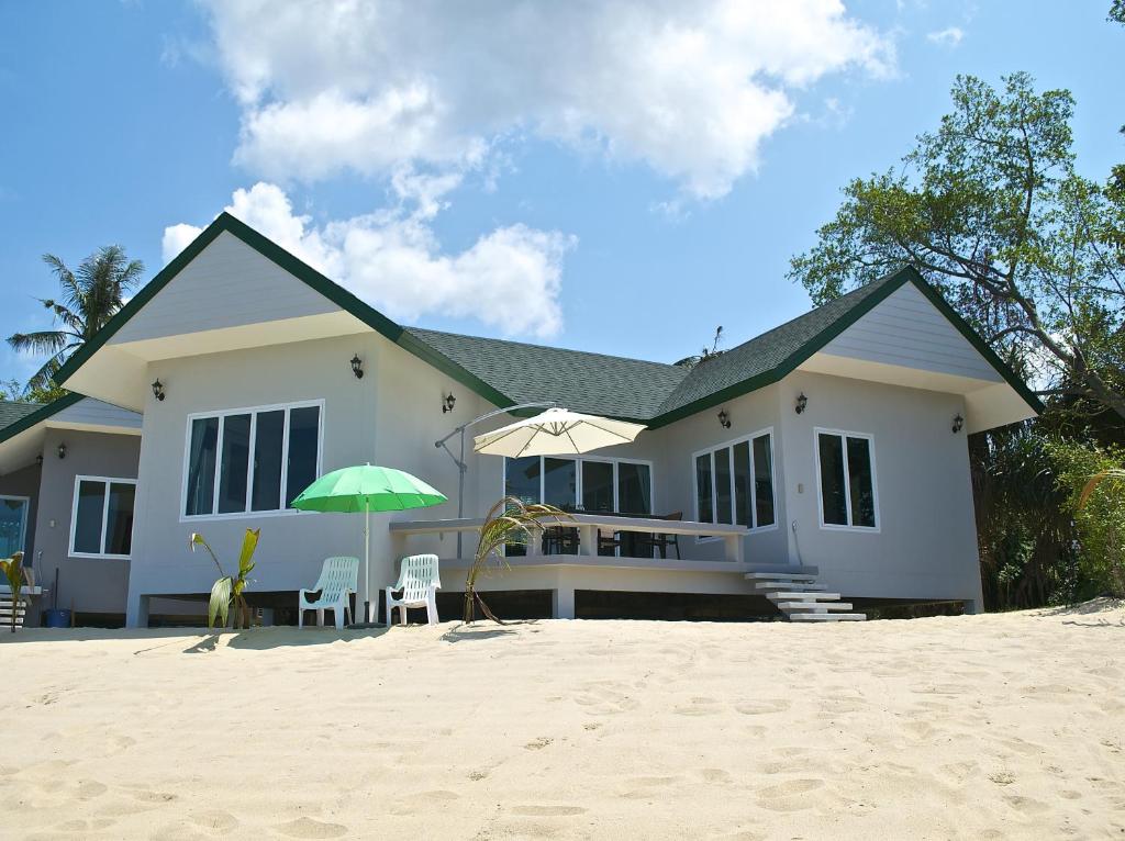 湄南海滩穆恩雷克尔斯别墅的海滩上带遮阳伞和椅子的白色房子