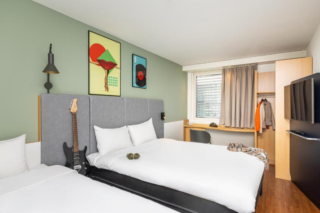 楚格巴尔楚格宜必思酒店的酒店客房设有两张床和吉他