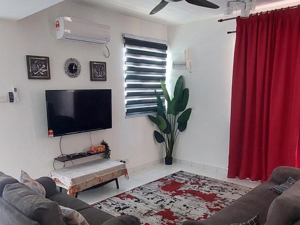 Kampong Alor GajahNur Homestay Residensi Afamosa mslim guest only的一间带电视和红色窗帘的客厅