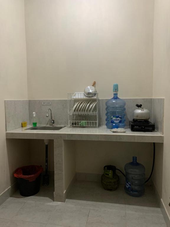 BesakihBesakih Homestay & Villa的带水槽的厨房台面和2瓶水