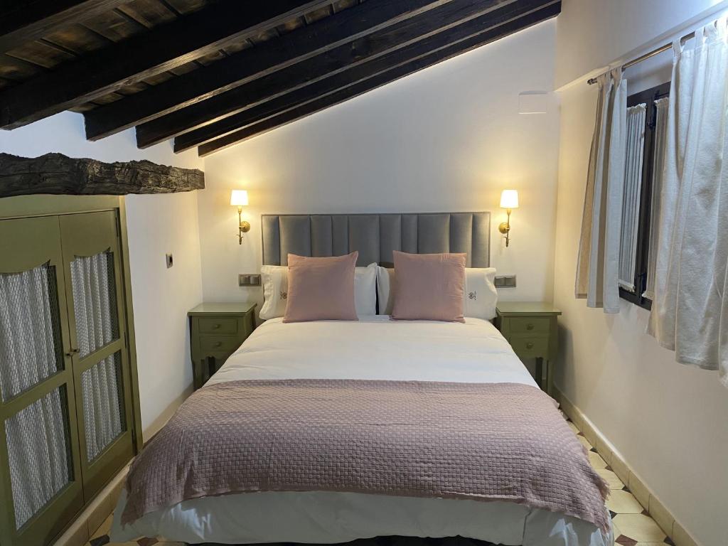埃尔瓦Apartamentos Rurales El Zarzo的卧室配有一张带粉红色枕头的大床