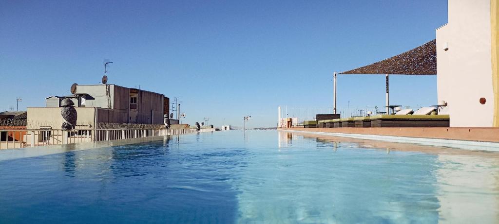略夫雷加特河畔奥斯皮塔莱特Hotel Orangine的一座建筑旁边的蓝色海水池