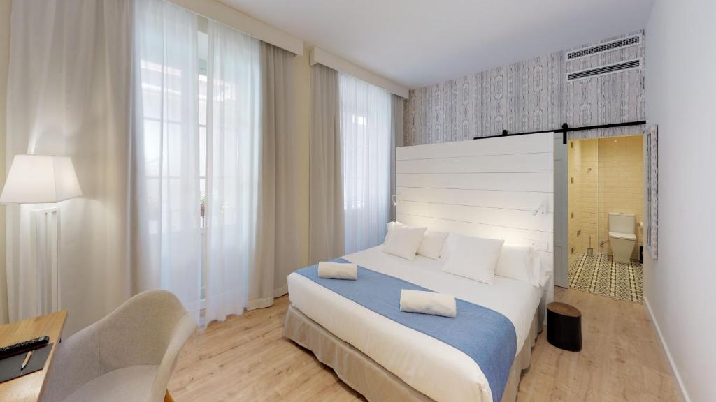 马拉加麦迪瑞奈酒店的一间卧室配有一张床、一张桌子和一把椅子