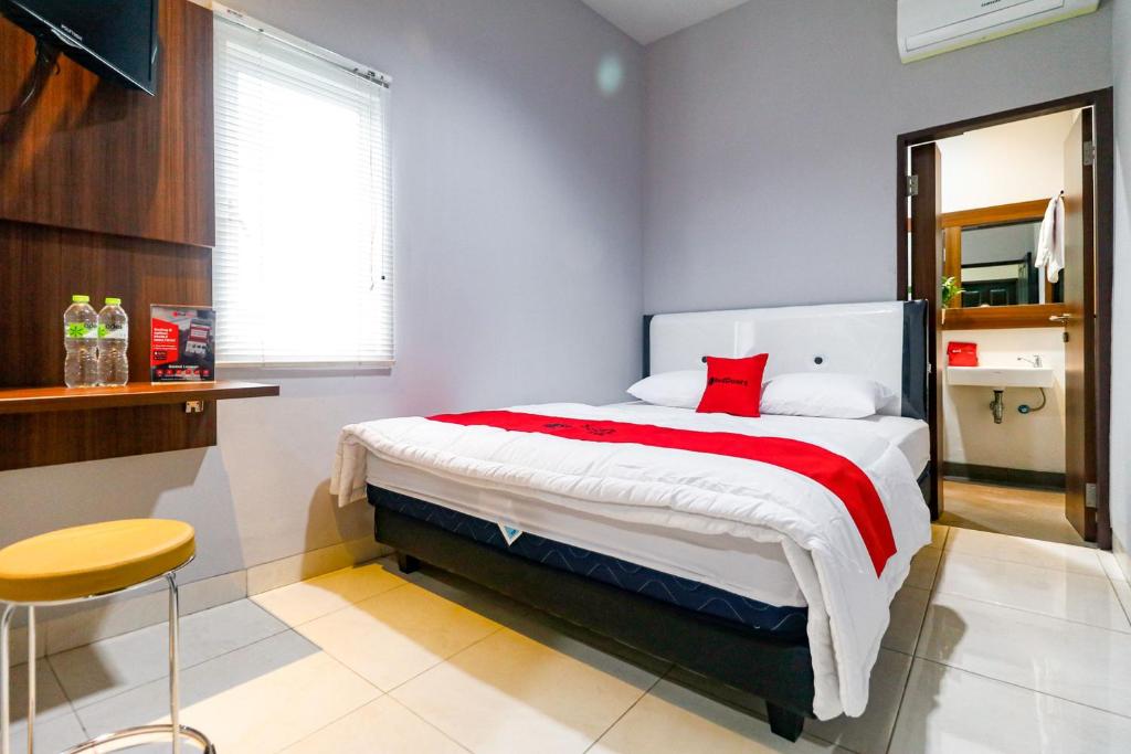 雅加达RedDoorz near Kebon Jeruk Jakarta的一间卧室配有一张带红色毯子的大床