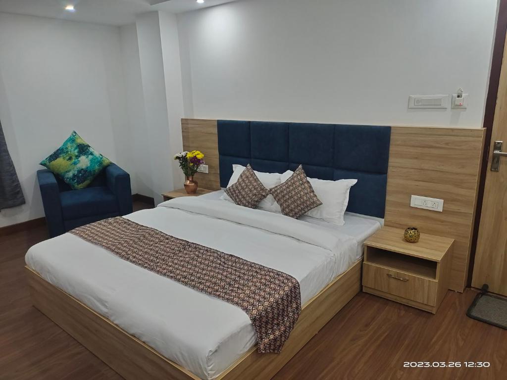 甘托克Shanol Residency的一间卧室配有一张大床和蓝色床头板