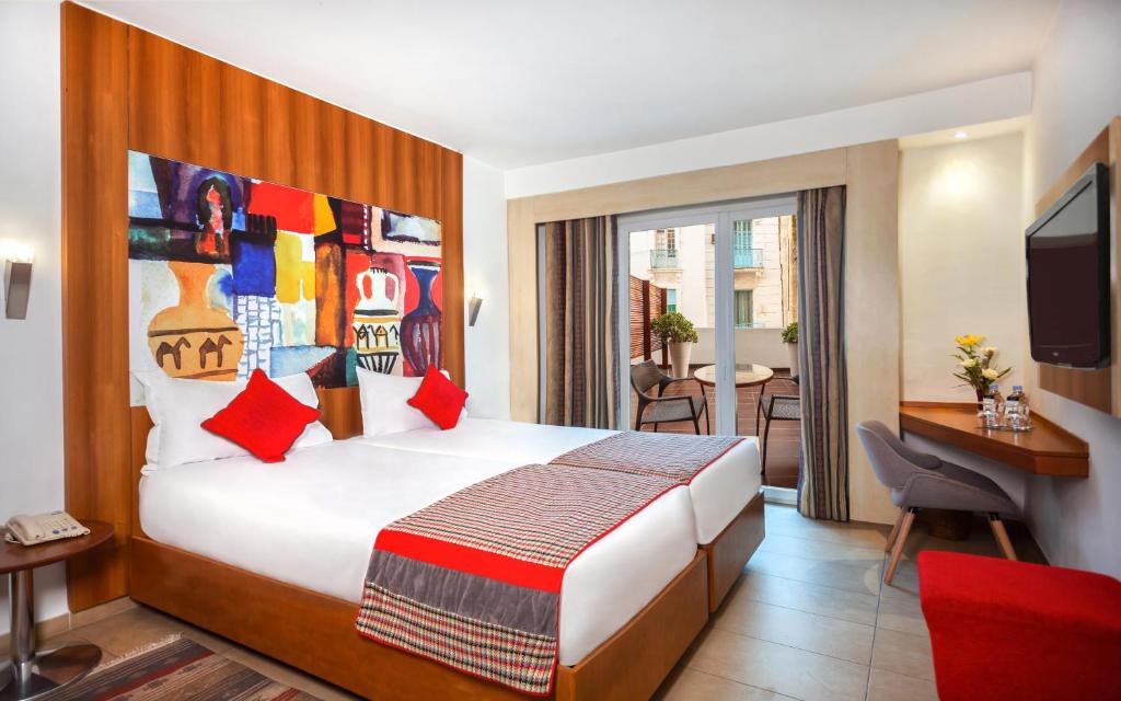 突尼斯卡尔顿酒店的酒店客房配有一张床、一张书桌和一台电视。