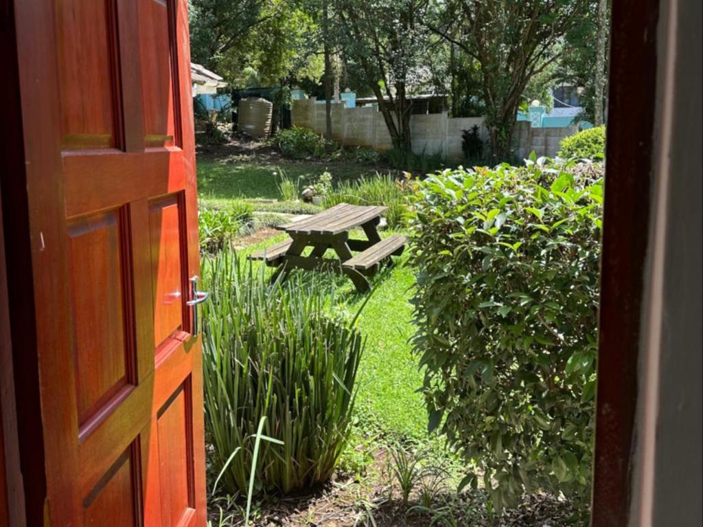 彼得马里茨堡Bogotá的通往带野餐桌的花园的开放式门
