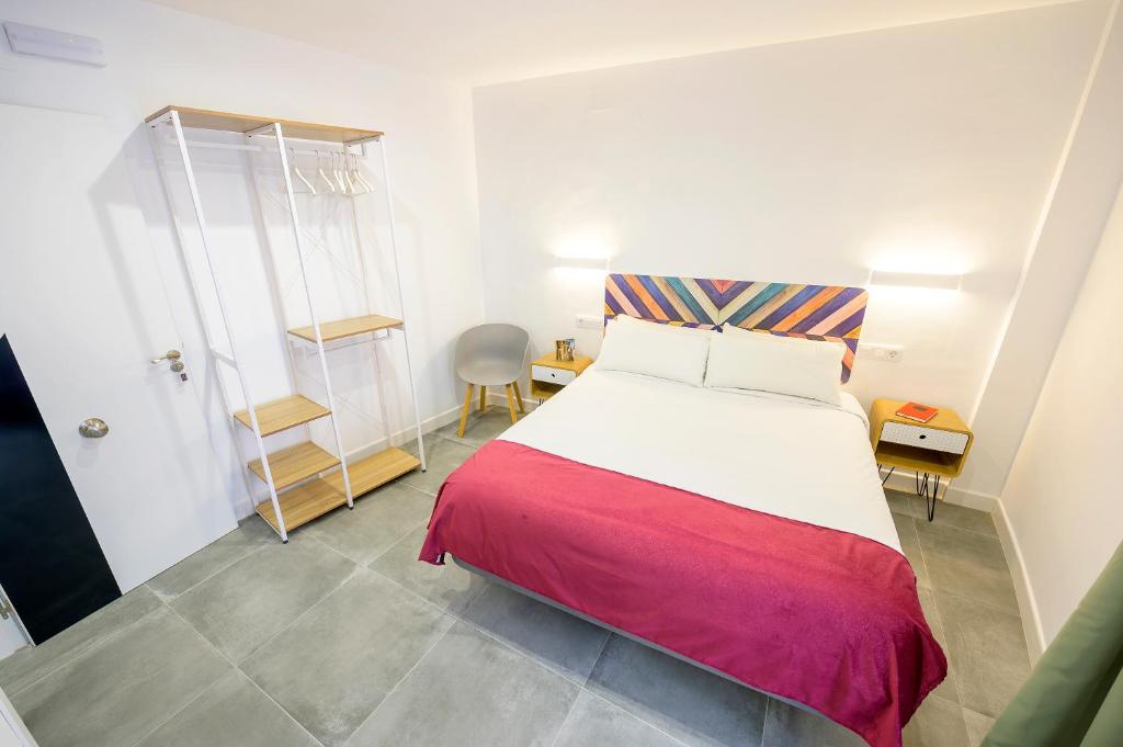乌贝达Hospedería La casa del Alarife的一间卧室配有一张带红色毯子的床