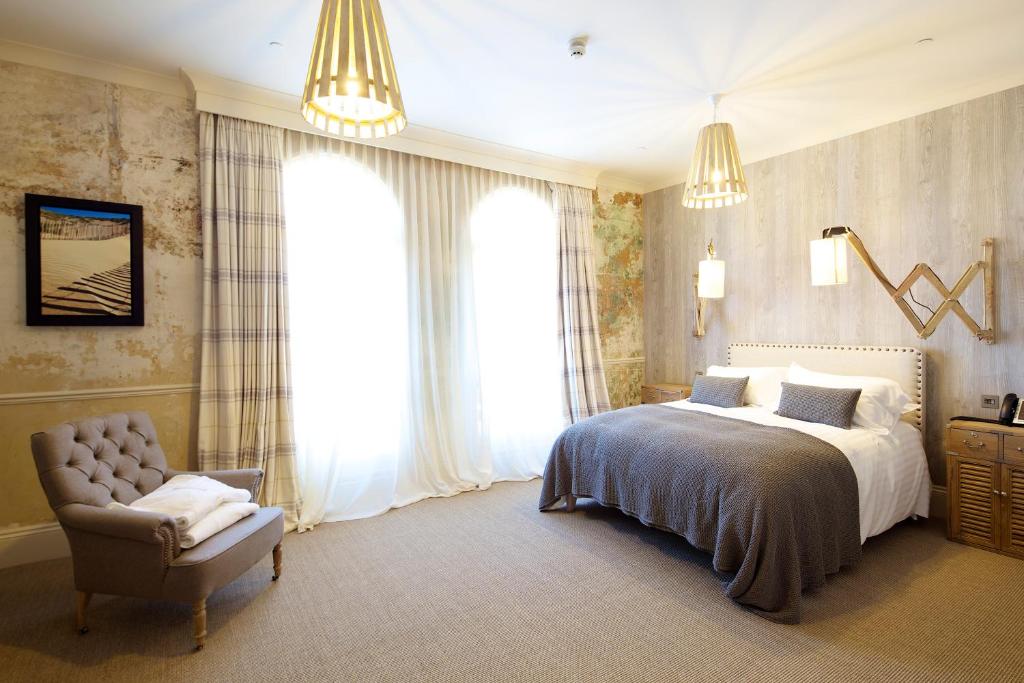 圣赫利尔泽西8 Beresford Street的一间卧室配有一张床、一把椅子和窗户。
