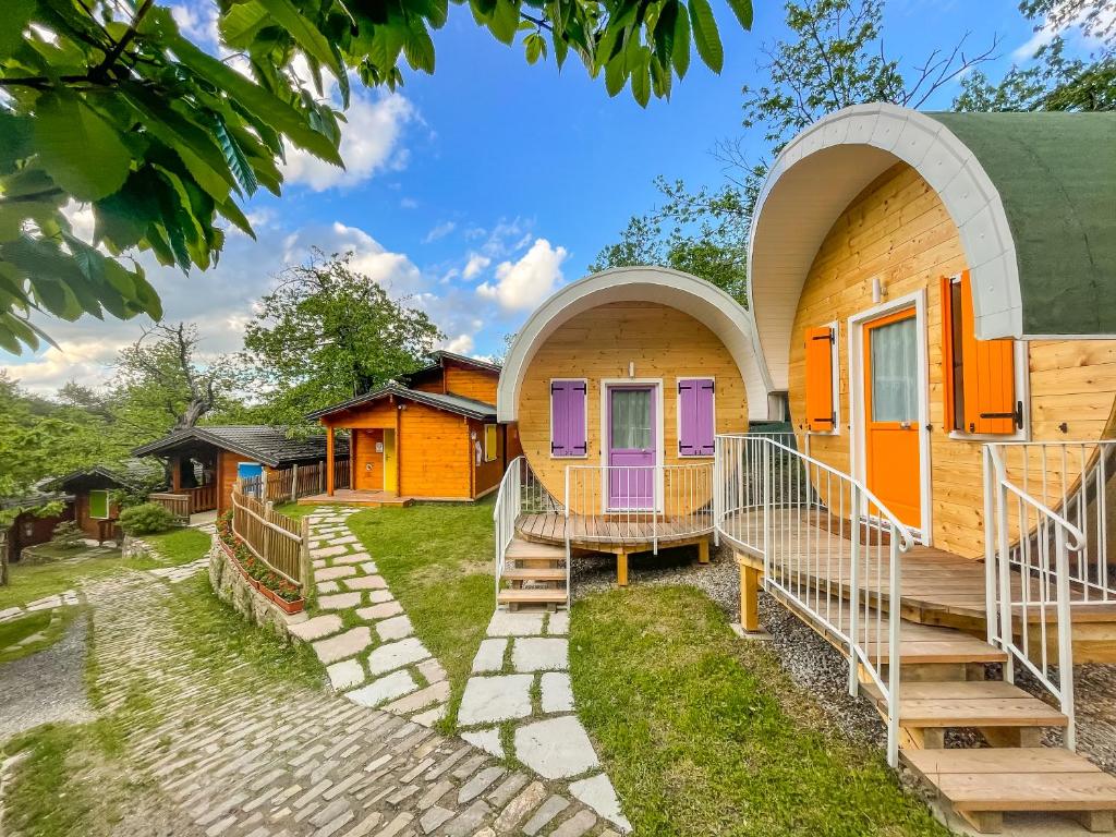 蒙泰克雷托Glamping Villaggio Parco Dei Castagni 4 stelle的一群橙色和紫色门的房屋