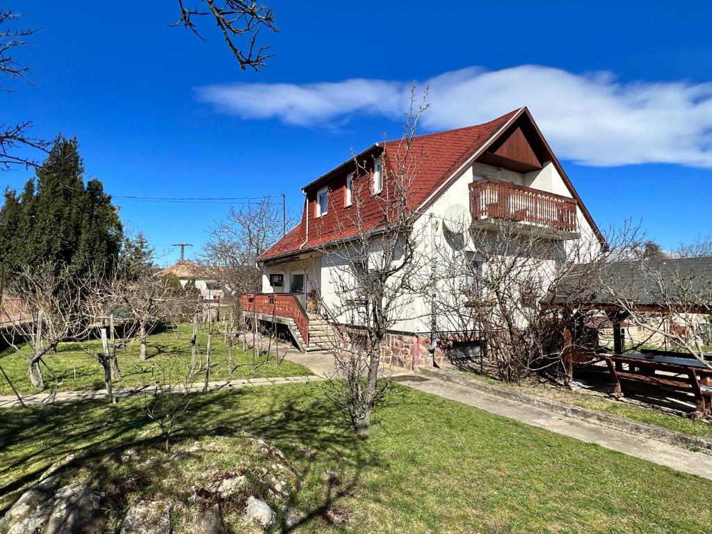 赞考A Festő Vendégháza / The Painter's Guest House的绿色田野上一座红色屋顶的房子