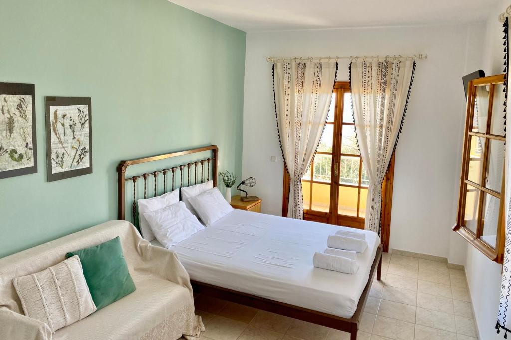 鲁维斯Armonia Elegant Apartments的一间卧室配有一张床、一张沙发和一个窗口