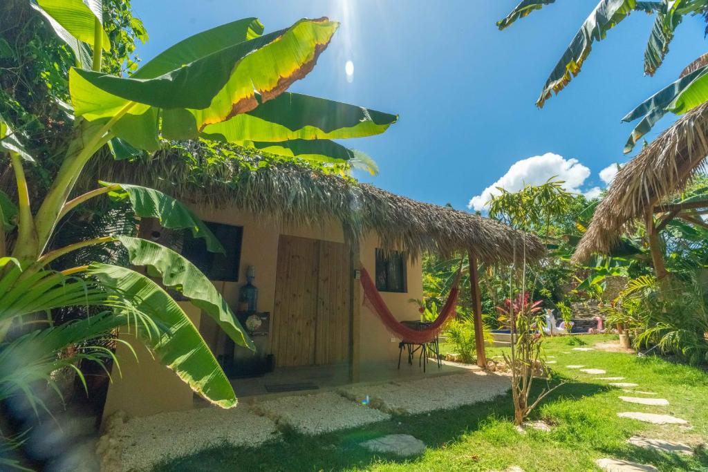 BombitaCasita Chinola - Playa El Encuentro的茅草屋顶和椅子的小房子