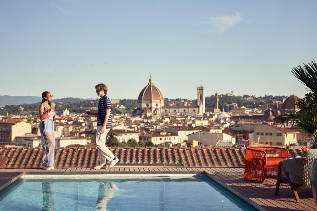 佛罗伦萨The Social Hub Florence Lavagnini的两个人站在一个城市的屋顶边缘