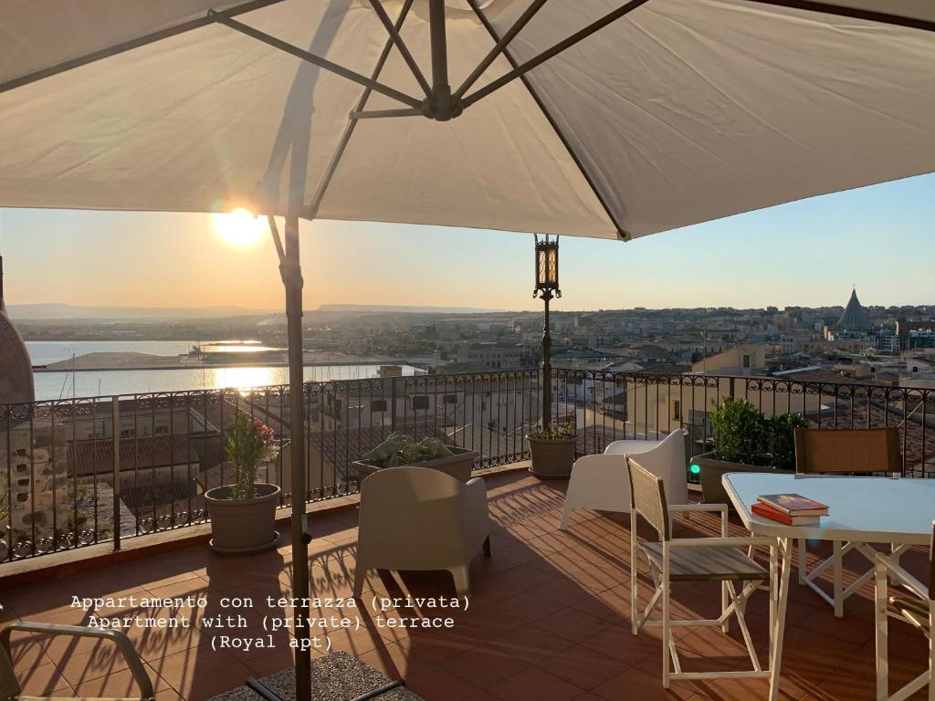 锡拉库扎Appartamenti di Casa VerbaVolant的庭院配有遮阳伞和桌椅。