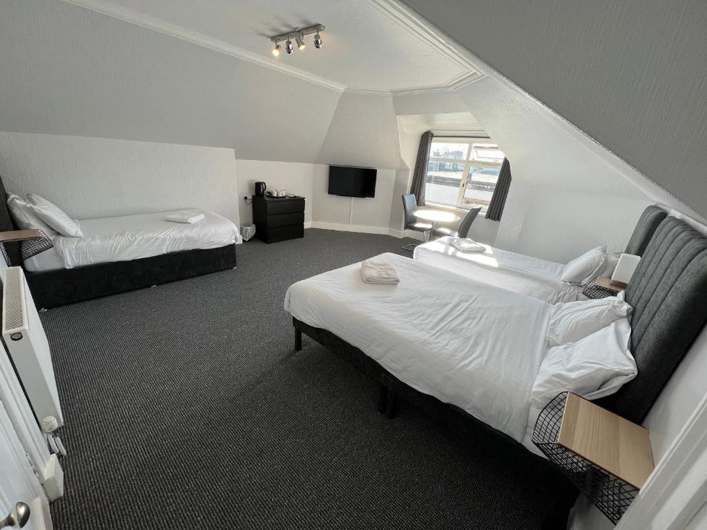 阿伯丁Lost Guest House Aberdeen的酒店客房设有两张床和窗户。