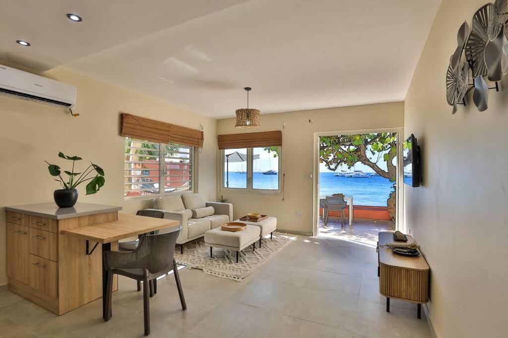 辛普森湾Hamaka condo a beachfront retreat on Simpson Bay Beach的厨房以及带桌椅的起居室。