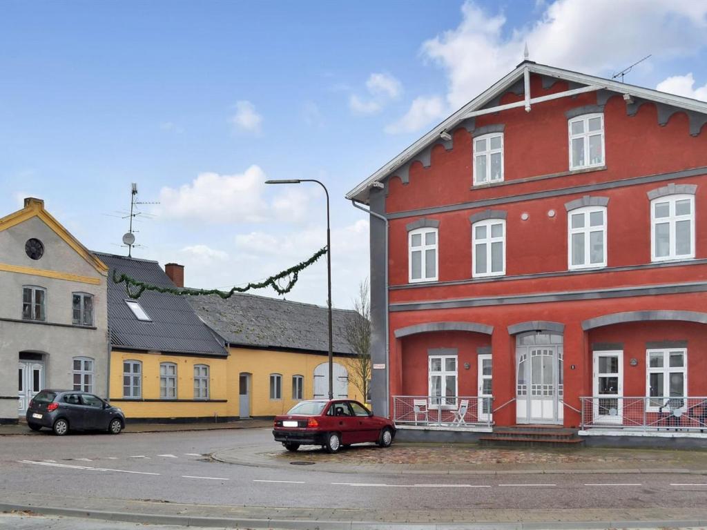 BredebroApartment Esja - 22km from the sea in Western Jutland by Interhome的一辆红色的房子,一辆红色的汽车停在街上