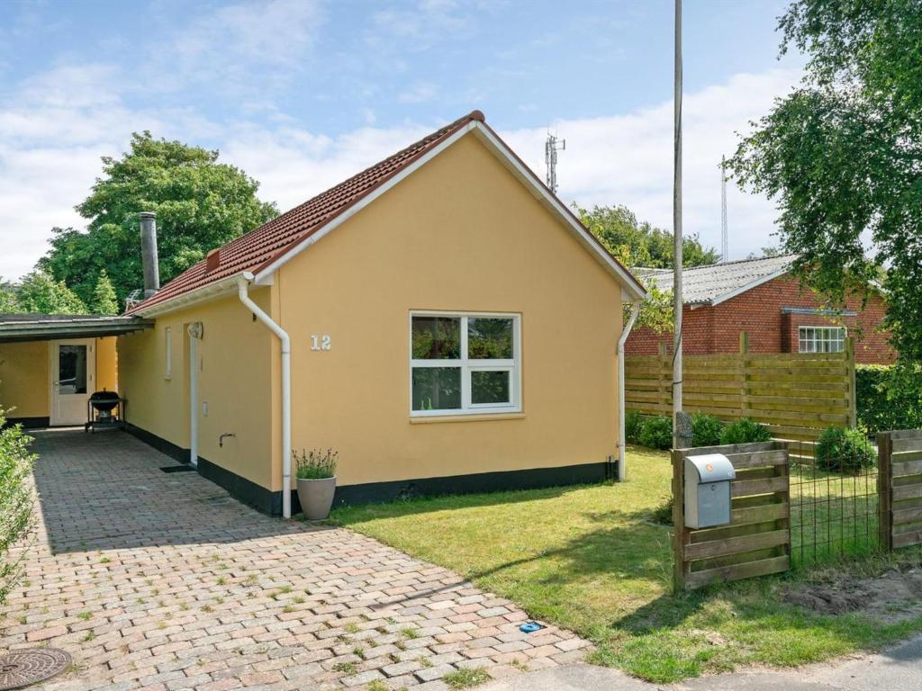 里伯Holiday Home Øthi in Western Jutland by Interhome的黄色的房子,有栅栏和院子