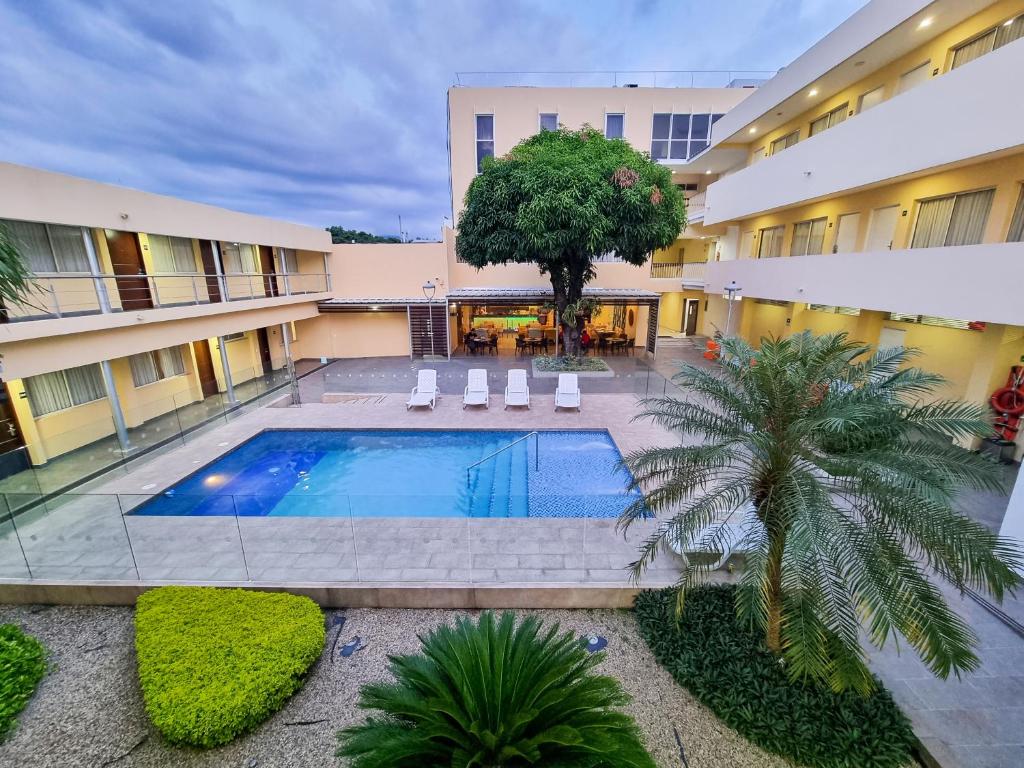 库库塔Hotel Arizona Suites Cúcuta的享有庭院的顶部景色,在大楼内设有一个游泳池