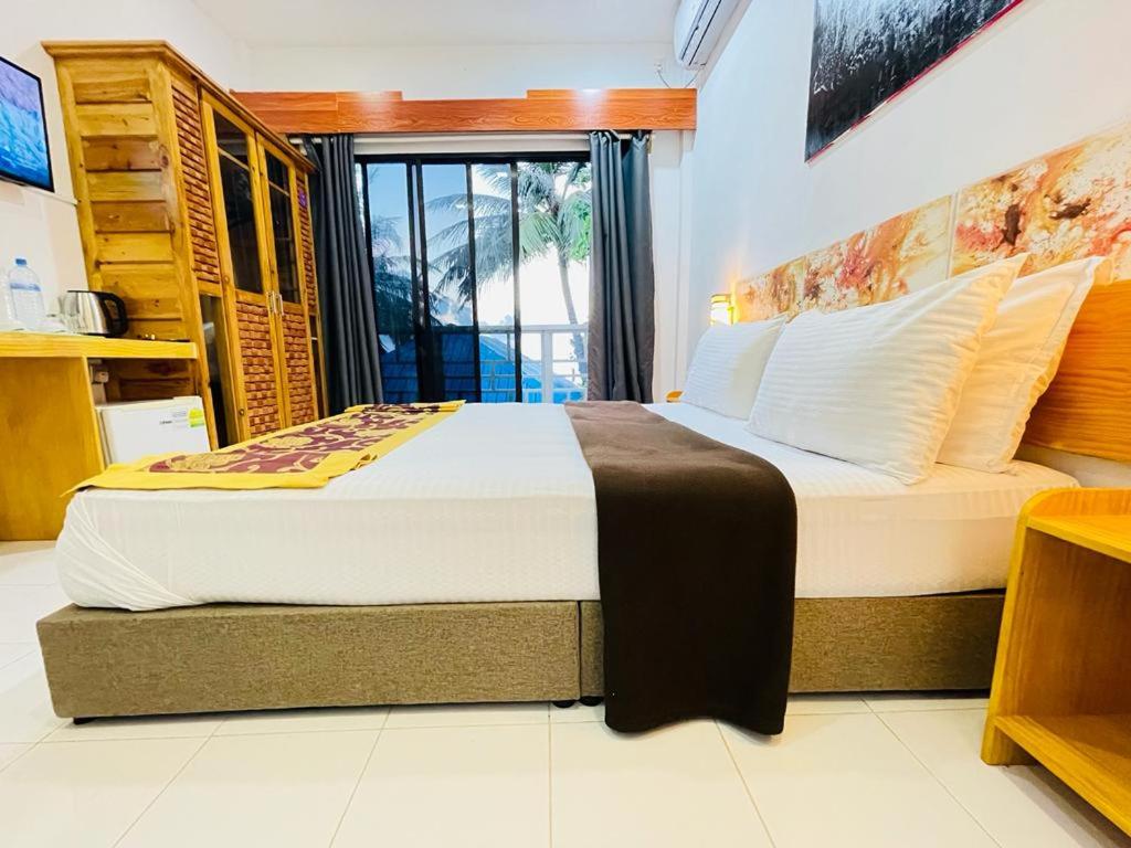 马富施Paradise Retreat, Maafushi的一间卧室设有两张床和窗户。