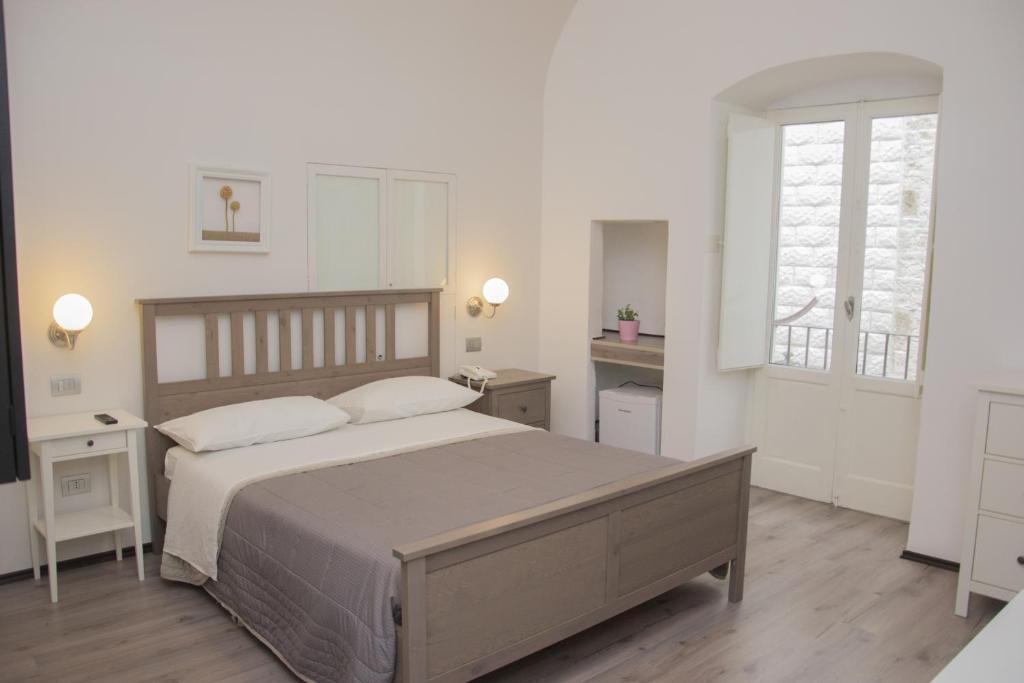 鲁沃迪普利亚B&B Cemener的白色的卧室设有一张大床和一个窗户