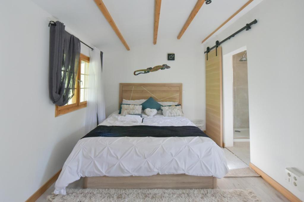 拉蒂尔比耶Wood Chalet 1 Monaco Forest La Turbie - Sleeps 5 people的一间白色客房内的床铺卧室