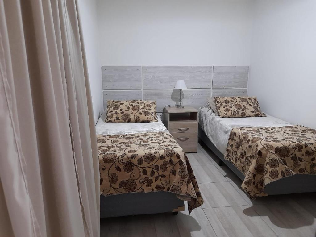 乌斯怀亚Monseñor Fagnano 592 "5"的一间卧室配有两张床和床头灯。