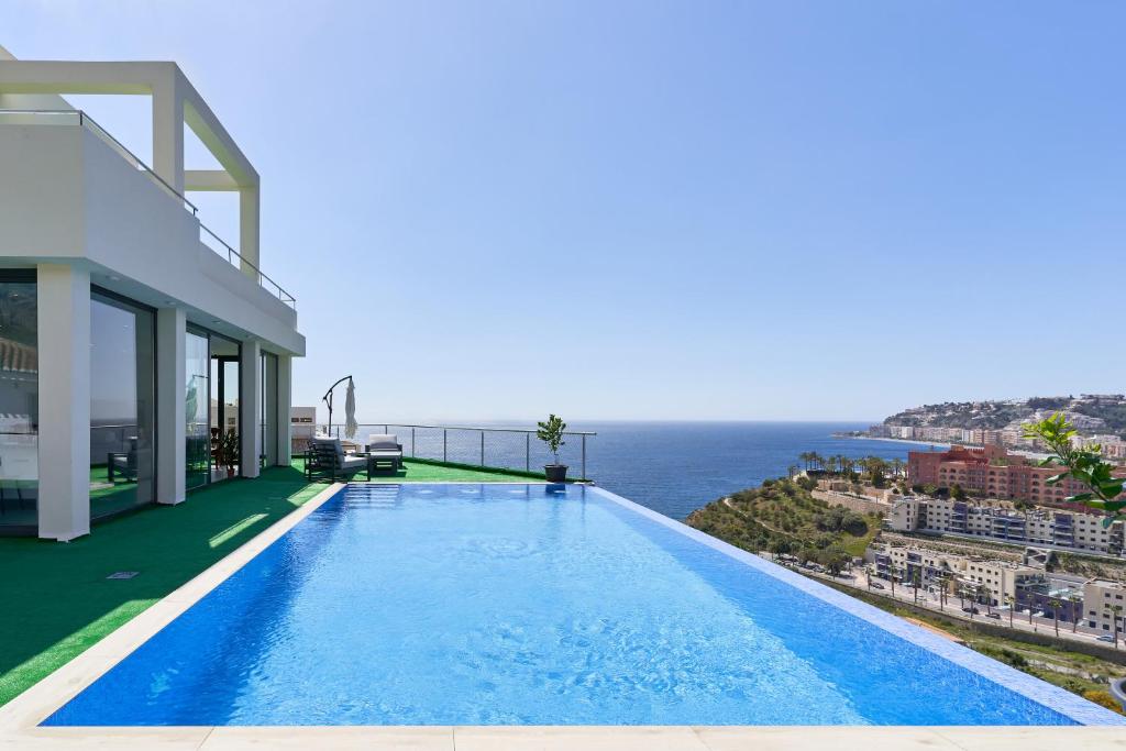 阿尔姆尼卡Villa Joya del Mediterraneo的一座位于海边的别墅旁的游泳池