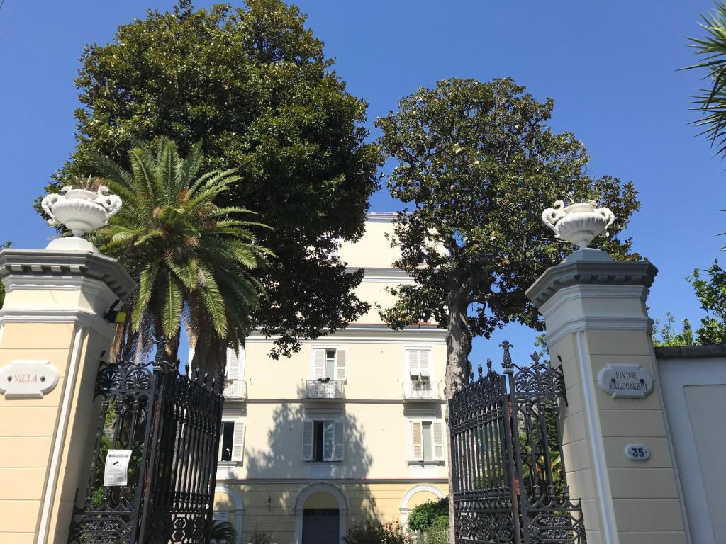 圣安吉洛Villa Falconieri Sorrento Suite的棕榈树建筑前的大门