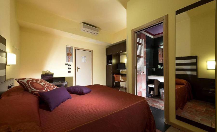 克雷斯佩拉诺Hotel Garden Bologna的一间卧室设有一张床和一间客厅。