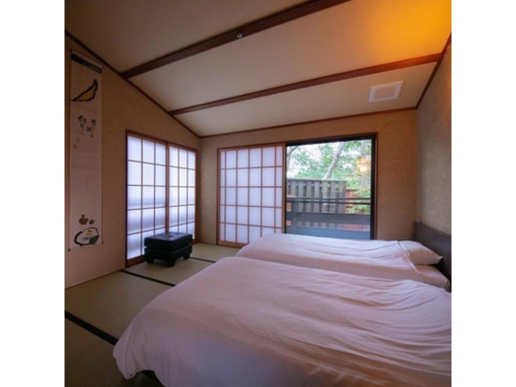 由布市Innterhill Tsubasa Yufuin - Vacation STAY 94239v的一间卧室设有一张大床和一个窗户。