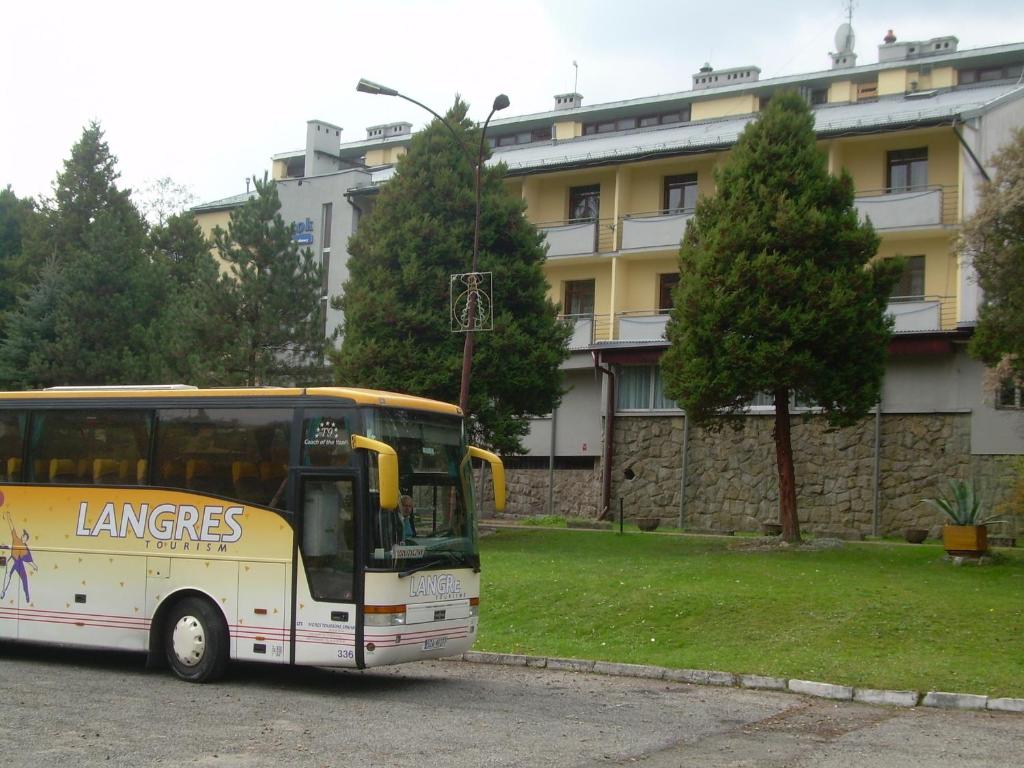 维斯瓦DW波托克度假村的停在大楼前的黄色巴士