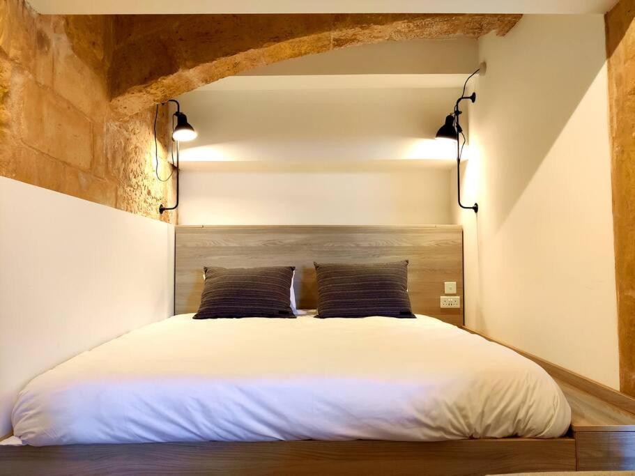 瓦莱塔Ripple 23 Savynomad Harbour Residences的卧室配有一张带两个枕头的大白色床