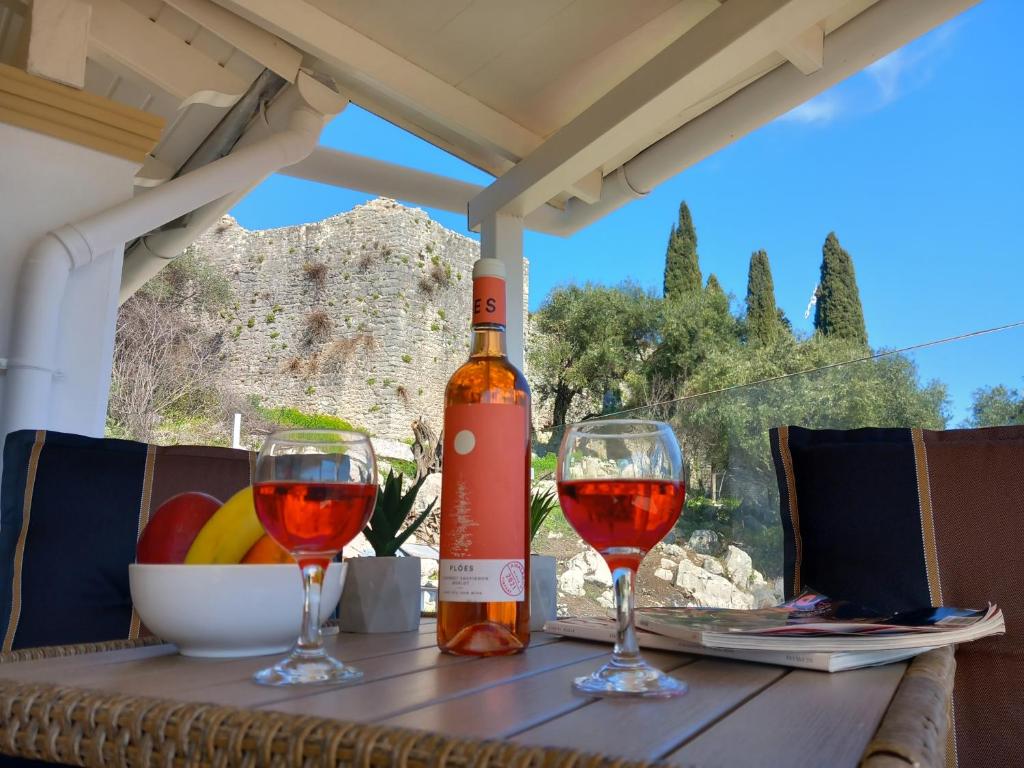 卡西奥皮Solaris Methea- Luxury Central Villa by the Castle的一张桌子上放着一瓶葡萄酒,放上两杯