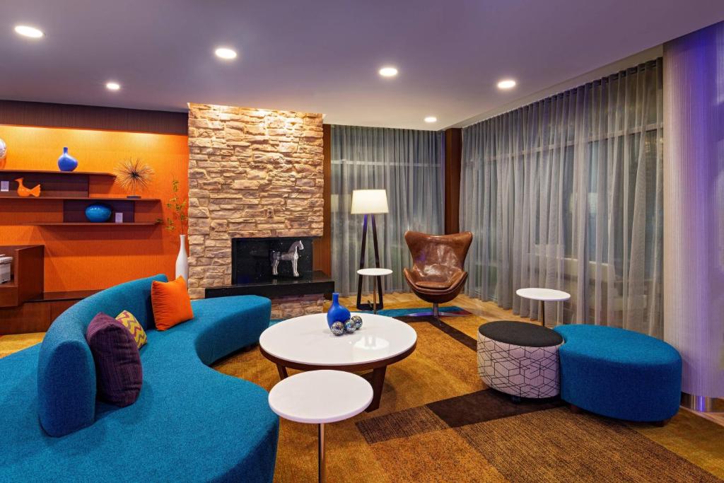 RichmondFairfield Inn & Suites Houston Richmond的客厅设有蓝色的沙发和壁炉