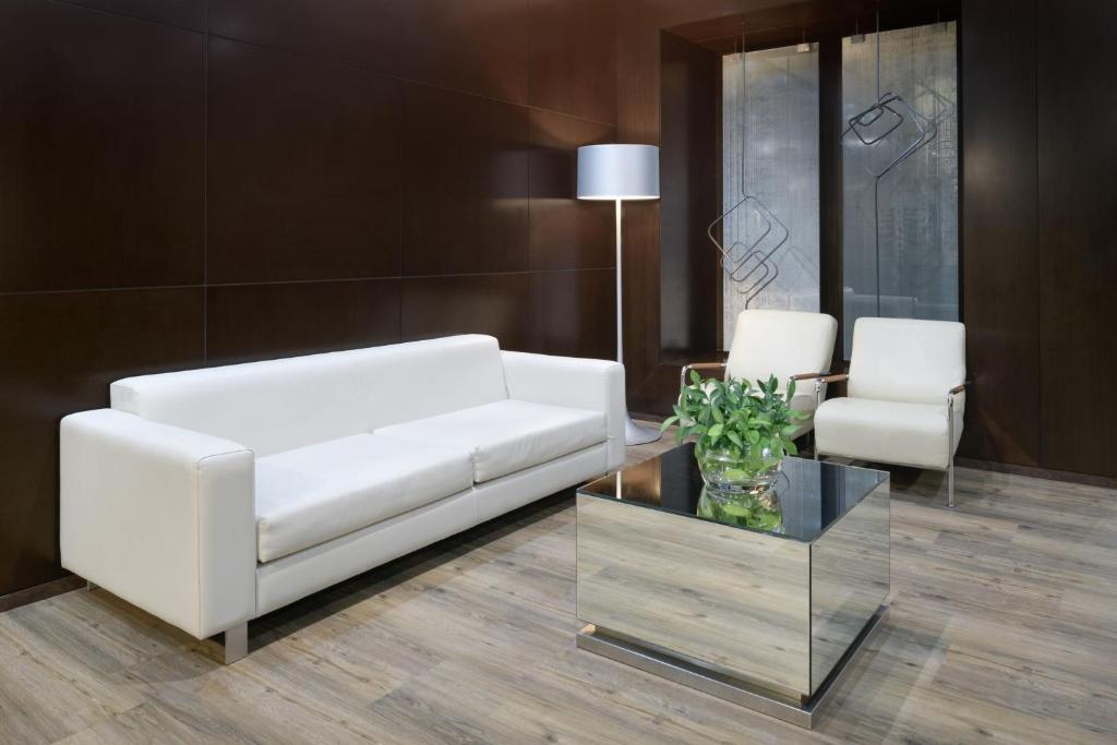 萨莫拉萨莫拉生活方式万豪AC酒店的客厅配有白色的沙发和桌子