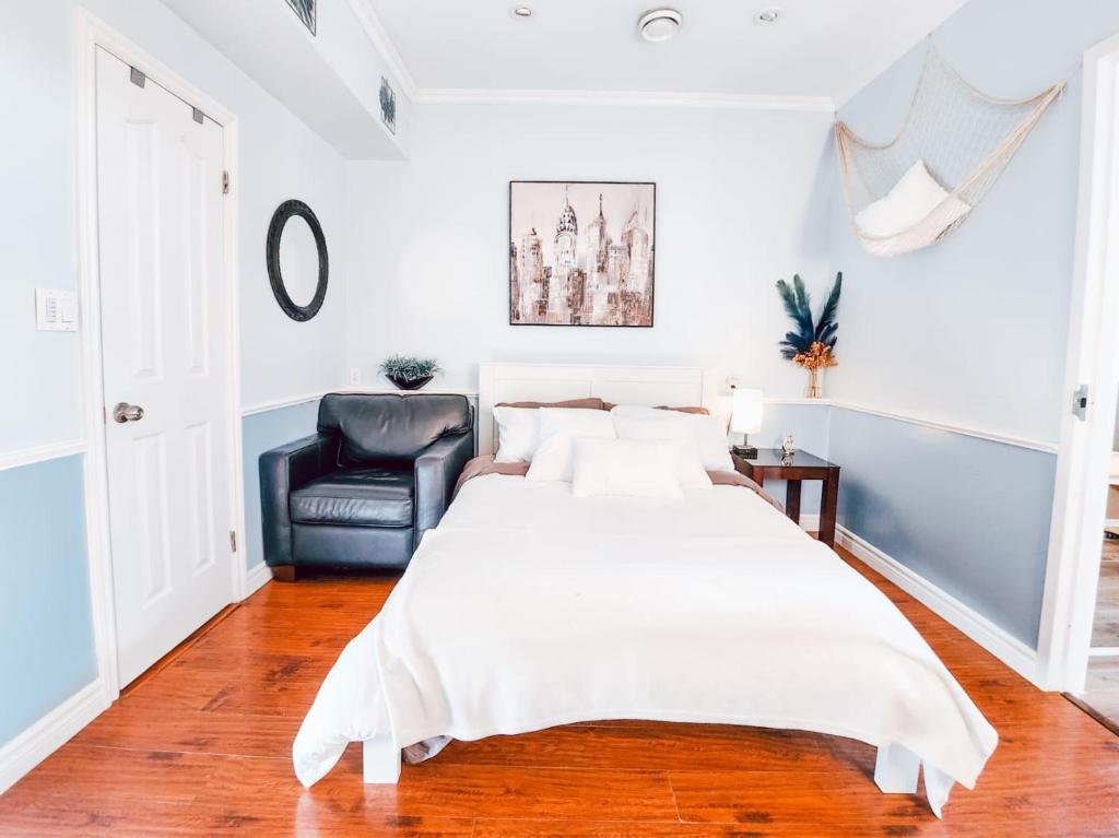 埃德蒙顿Hotel-Like stay!的卧室配有一张白色大床和一张黑椅