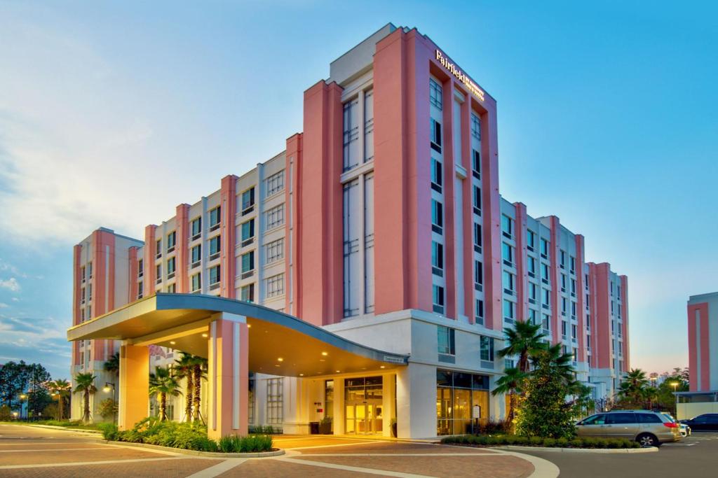 奥兰多Fairfield by Marriott Inn & Suites Orlando at FLAMINGO CROSSINGS® Town Center的一座红色的大建筑,设有停车场