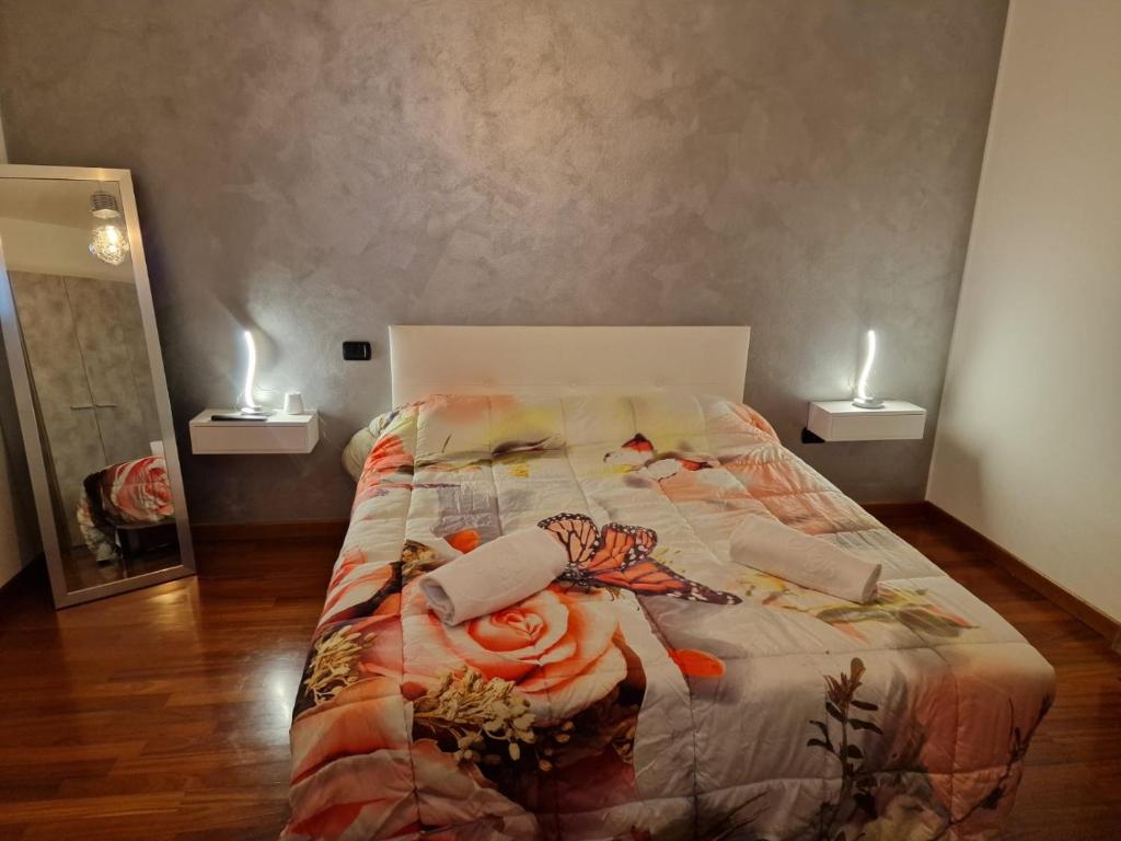 RovolonAppartamento Vacanze Euganea的卧室内的一张床铺,地板上设有两把蜡烛