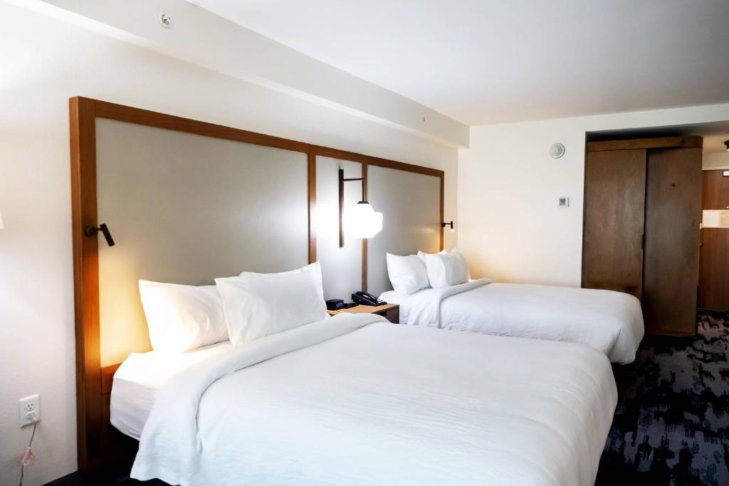 路易斯威尔Fairfield by Marriott Inn & Suites Louisville Airport的配有白色床单的酒店客房内的两张床