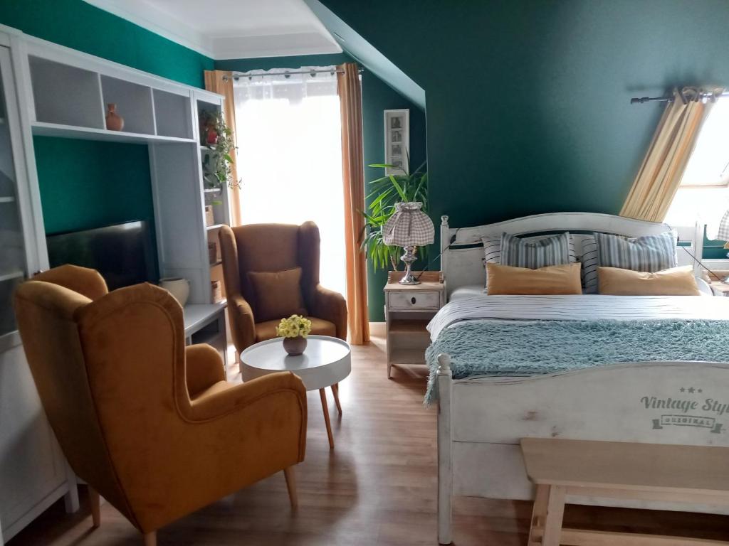 斯诺科白玉兰客房旅馆的一间卧室设有绿色的墙壁、一张床和两把椅子
