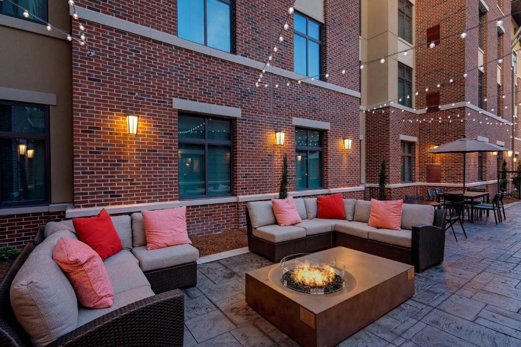 萨默维尔Residence Inn by Marriott Charleston Summerville的一个带沙发和桌子的庭院和一座砖砌建筑