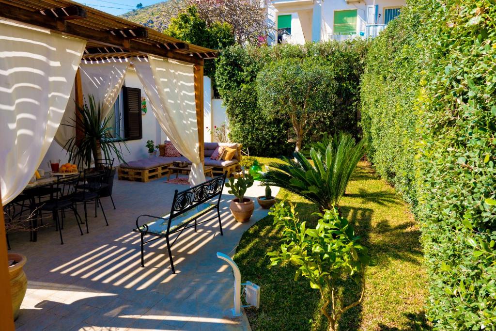 蒙德罗Villa Cinzia的一个带长凳和树 ⁇ 的花园