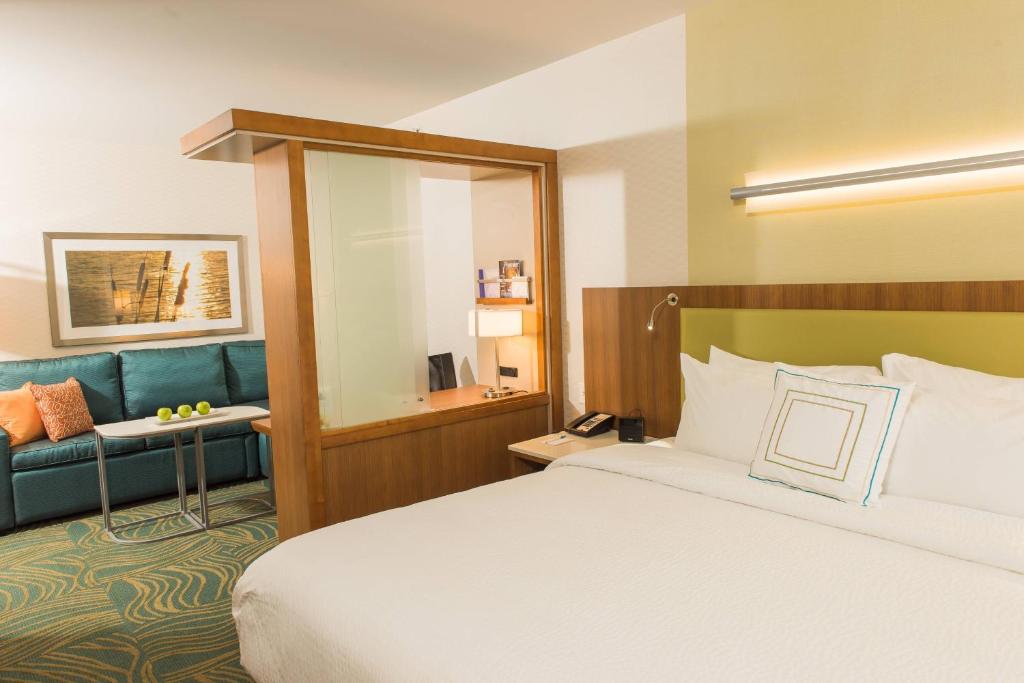 威廉斯维尔万豪布法罗机场春季山丘套房酒店的酒店客房,配有床和蓝色的沙发