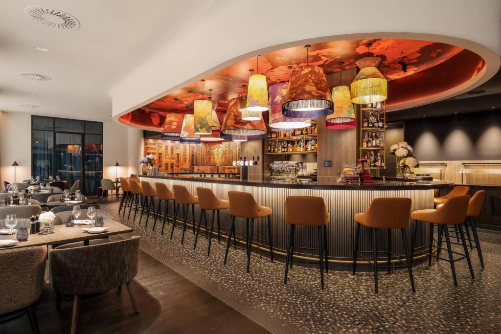 布鲁塞尔布鲁塞尔万丽酒店的餐厅设有酒吧,配有桌椅