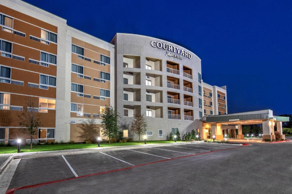 奥斯汀Courtyard Austin by Marriott Northwest/Lakeline的前面有停车位的大楼