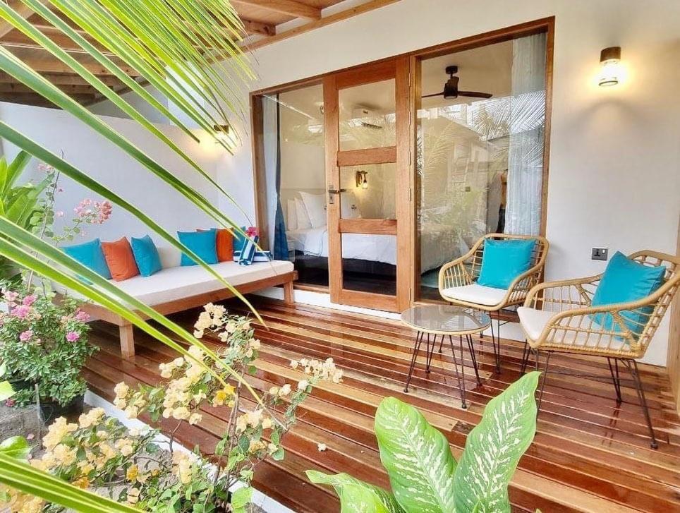 迪古拉Seaside Dhigurah的客房设有带椅子和床的阳台。