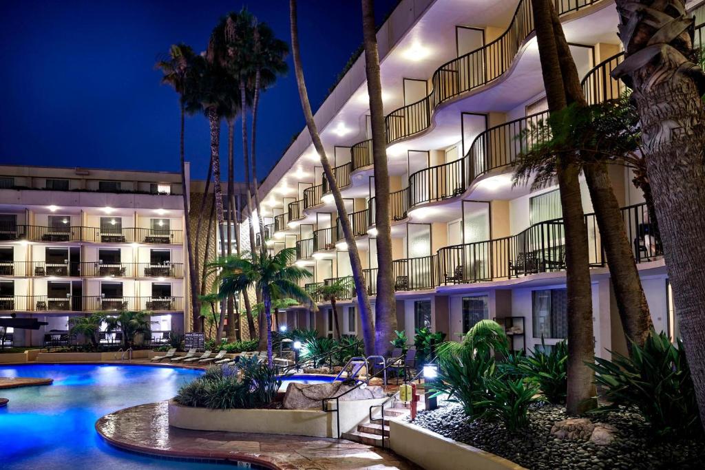 洛杉矶洛杉矶机场万豪酒店的夜间有游泳池和棕榈树的酒店